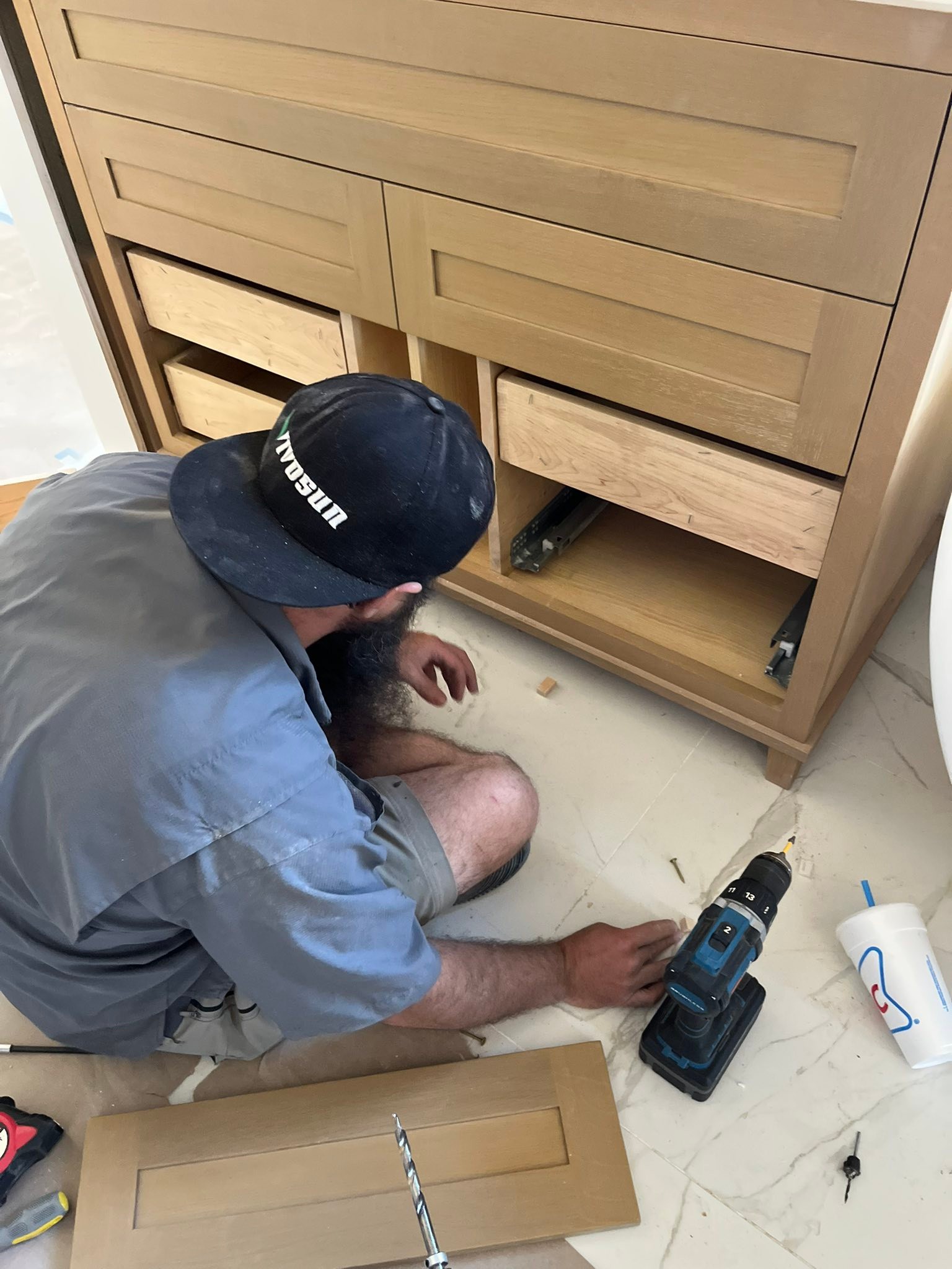A professional carpenter repairing a cabinet