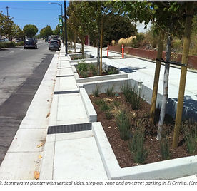 Image of tree wells along a side walk and road way. Trees are planted in each area.