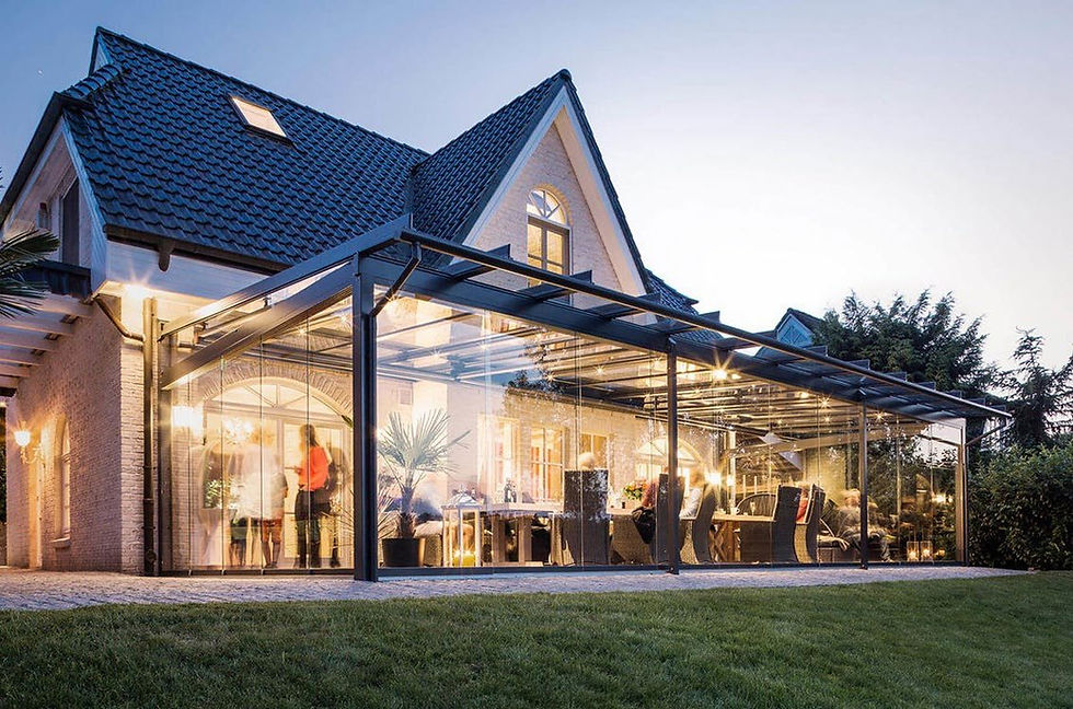 MFP glass wintergarden lit up at dusk beside a modern house
