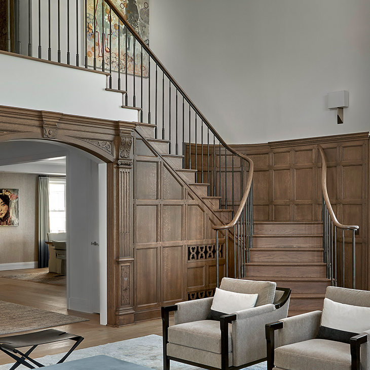 Updated staircase with metal balusters and restored paneling in a Chicago renovation by Jaffe Architecture, giving new life to a once outdated great room