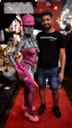 Airbrush Hero Avi Ram with model in Fortnite robot girl pink and silver airbrush body paint at Fantasy Fest Key West