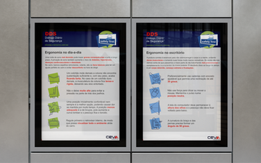 Murais com informativos de segurança e saúde ocupacional fixados em ambiente de escritório.