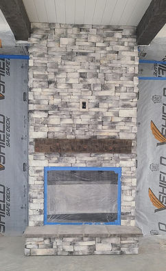 Drystacked gray and white manufactured stone veneer creates a beautiful fireplace.