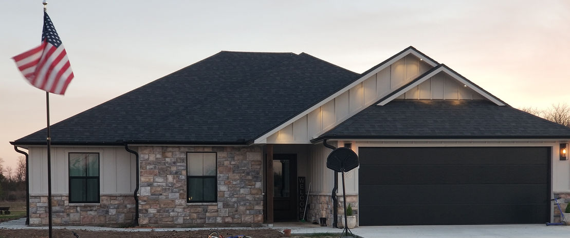 Charming home with off-white siding and multi-colored stone veneer accent areas.