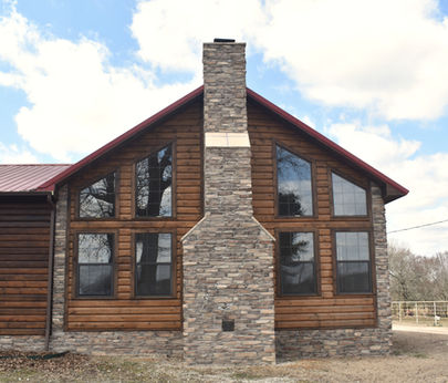 Rustic Ledgestone rock chimney on log house.