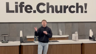 Guy talking in front of a Life.Church sign.