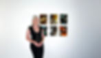 Contemporary artist Stephanie Gillett standing beside six alcohol-ink artworks from The 1992 Collection, featuring fluid earth-tone marbling and genuine 24k gold-leaf details on a gallery wall