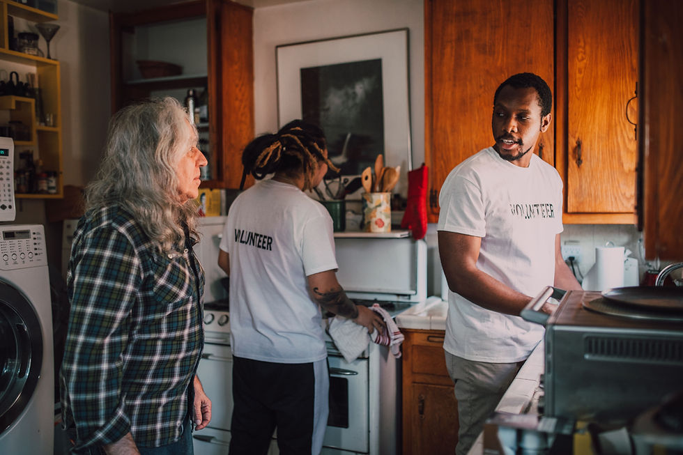 Volunteers support an elder with cleaning their home. Small organizations doing community work may be eligible for Sliding Scale pricing for wellness programs