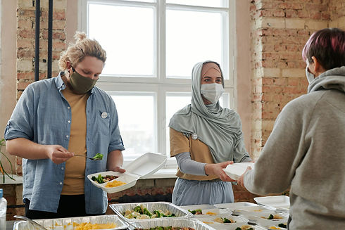 staff at a non-profit serve food in a food kitchen