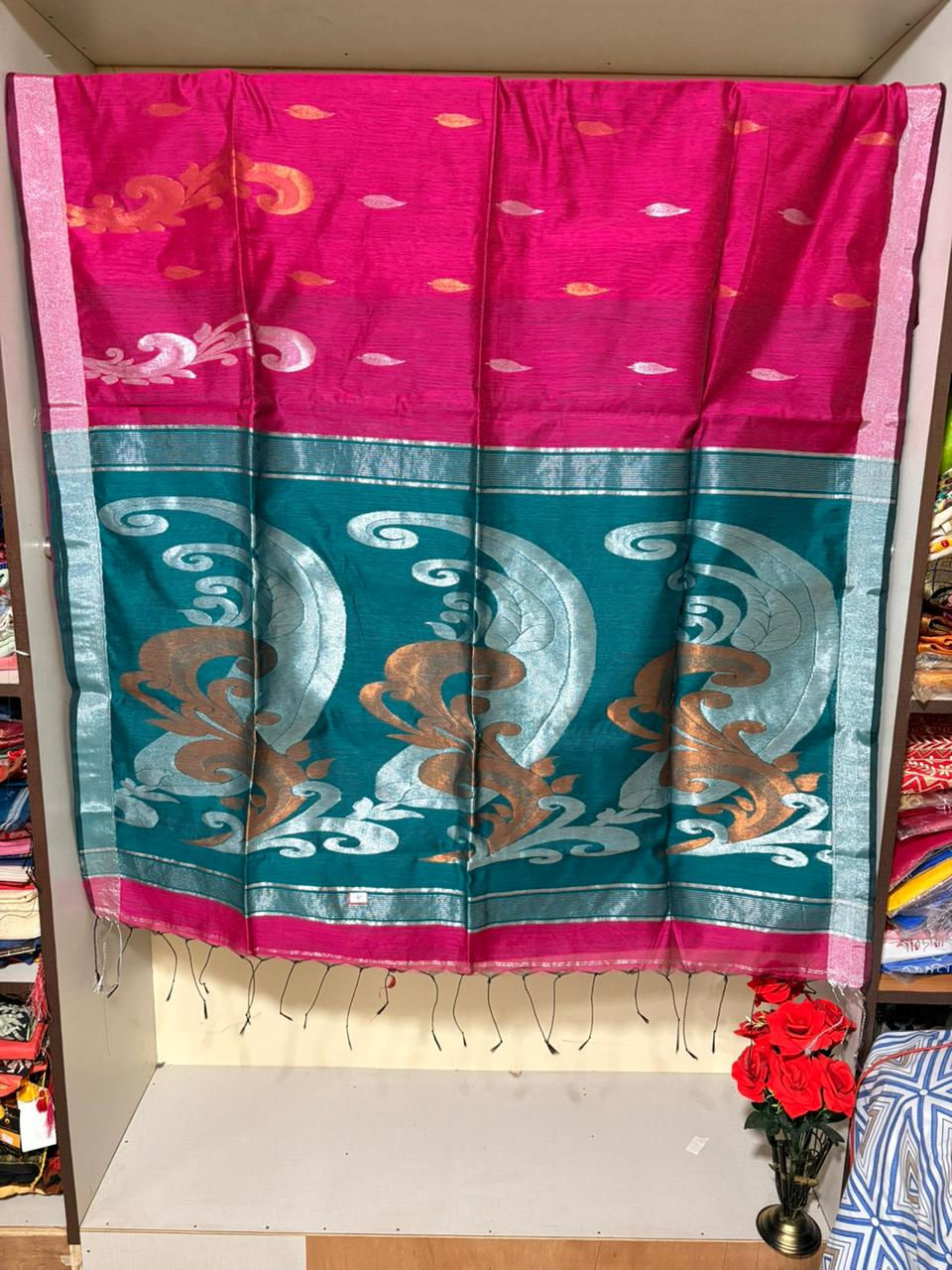 Indian woman wearing a dark Blue and copper woven saree with intricate floral motifs and patli pallu.