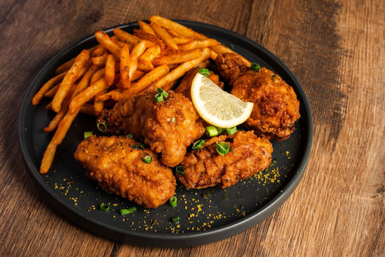 A plate of fried chicken wings and french fries