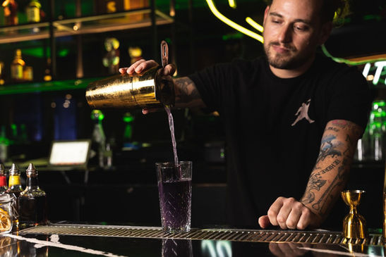Bartender pouring our Jasmine Collins cocktail
