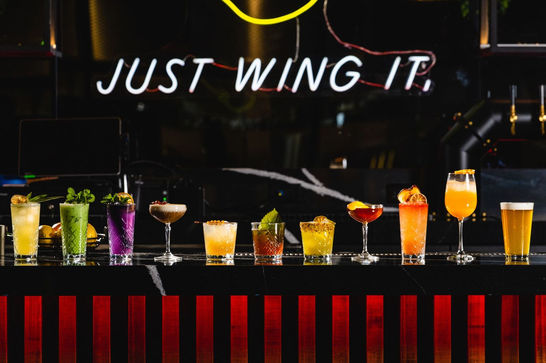 A lineup of specialty craft cocktails on the bar top at Cross Street Del Mar