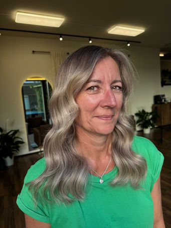 Front and back view of a woman with a custom grey blending balayage featuring soft blonde dimension, seamless root blending and natural-looking grey coverage at Emberyl Hair Atelier in Zürich.