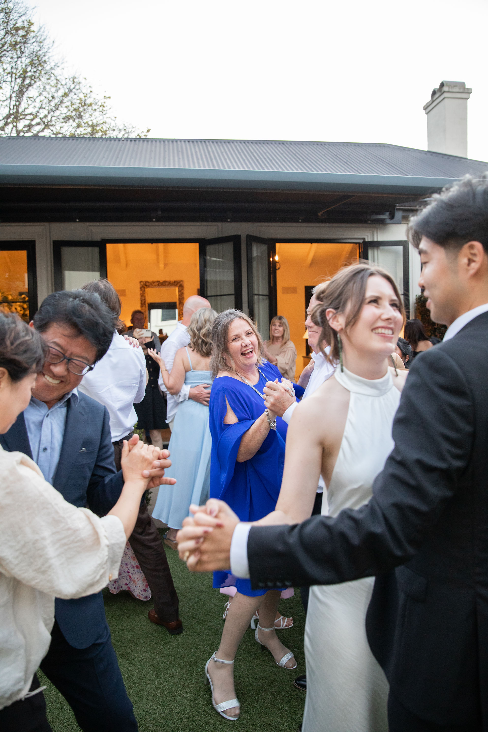 Bride and groom dancing with their wedding guests after their first dance