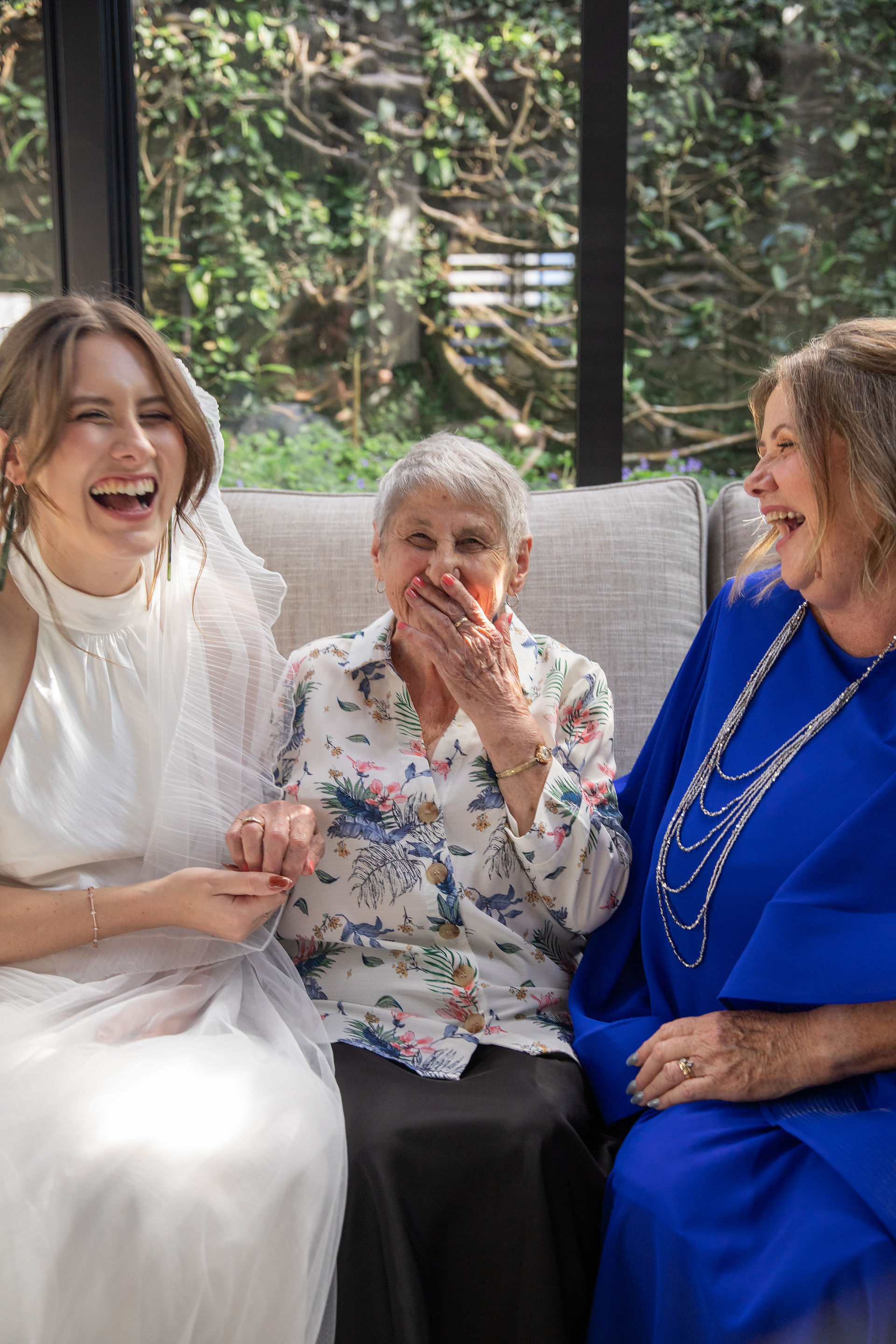 Bride, mother and grandmother share a funny moment together at wedding reception