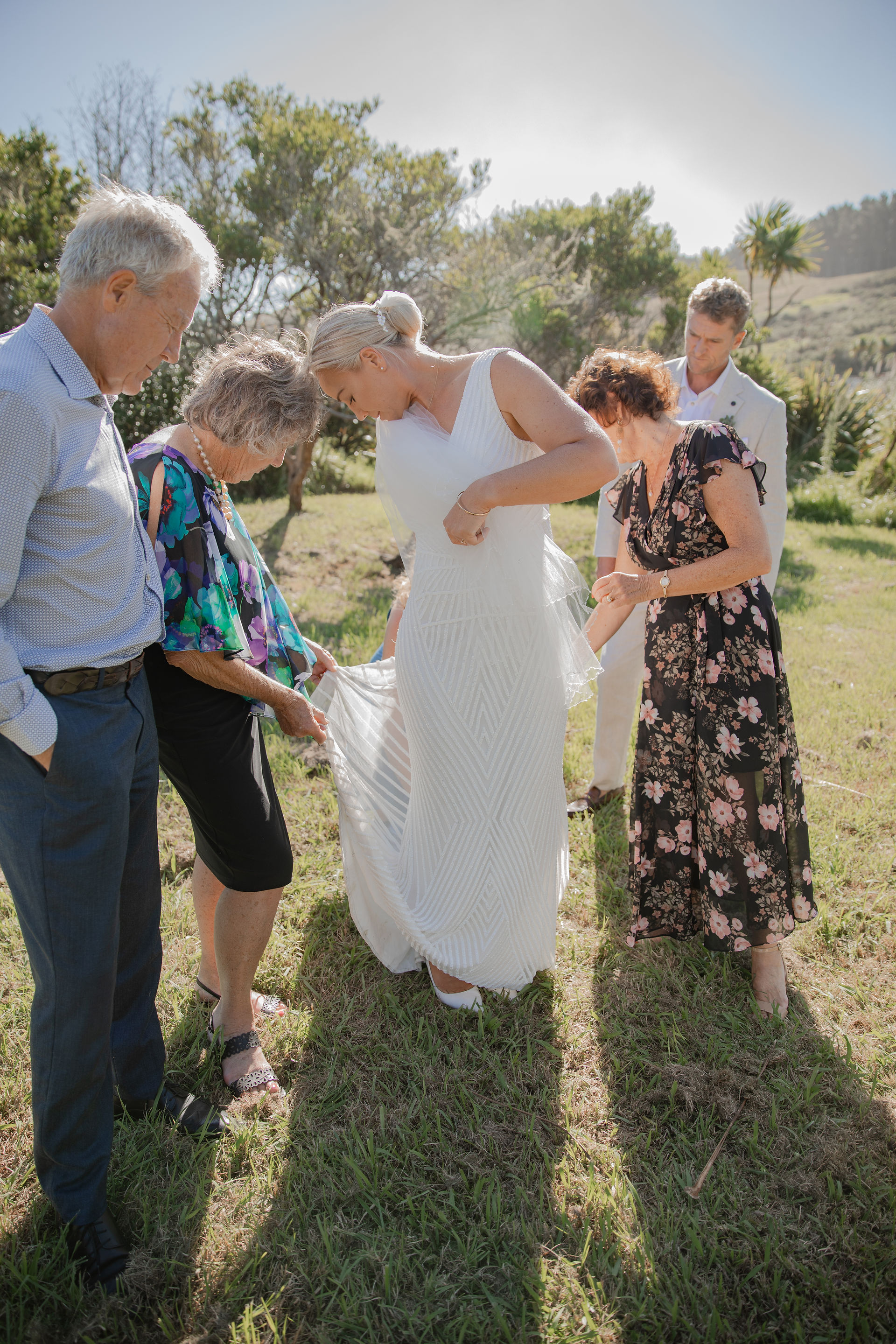 Family helping to bustle the wedding dress