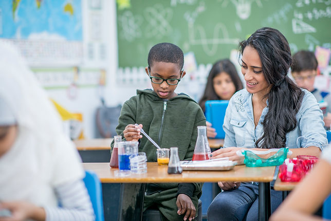 Female science teacher working with student