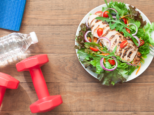 Healthy lifestyle essentials including a grilled chicken salad, dumbbells, yoga mat, and water bottle, symbolizing simple daily habits that support better health and longevity.