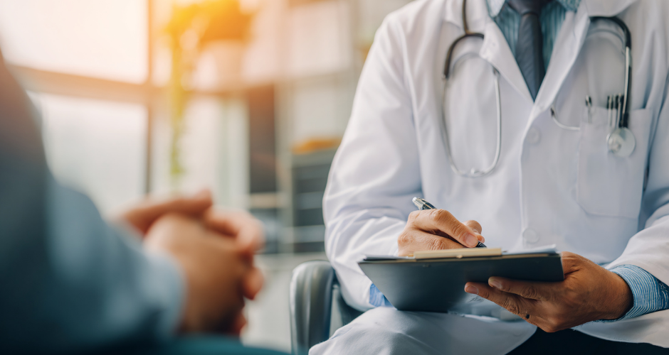 Doctor in white coat writes on clipboard, consulting with patient. Sunlit medical office with window in background. Calm, professional mood.