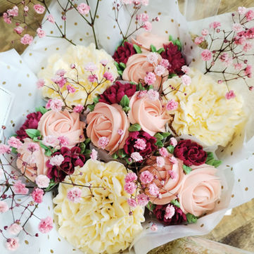 Un bouquet de 7 cupcakes délicatement décorés en blanc, rose pâle et rose fuchsia, presque violet, pour un effet printanier et frais. Chaque cupcake est sublimé de petites boutons de gypsophile, ajoutant une touche légère et aérienne, idéale pour une occasion festive et pleine de douceur. 