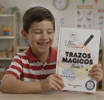 Niño feliz mostrando el libro Trazos Mágicos, Tomo 1
