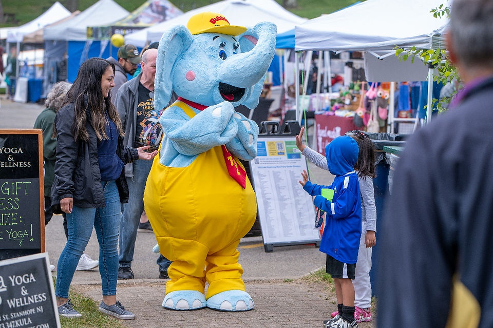 Large blue and white cartoon mascot greeting a small child