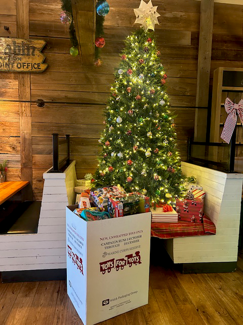 Toys for Tots Donation bin in front of Christmas tree