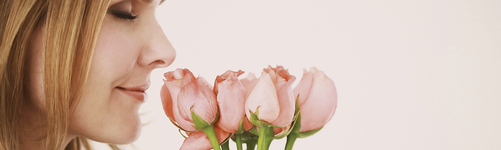 Frau riecht an Rosen