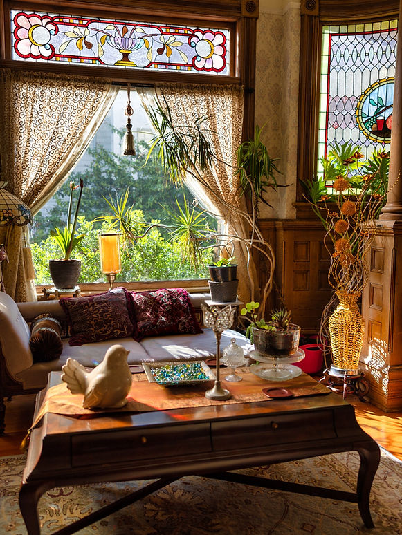 Sunlit sitting room with stained-glass windows at Haterleigh Heritage Inn in Victoria, British Columbia.