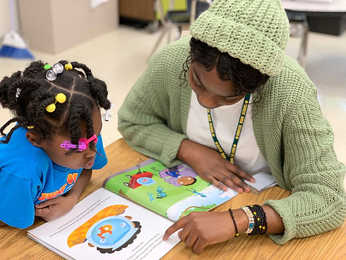 Black women reading with black student.j
