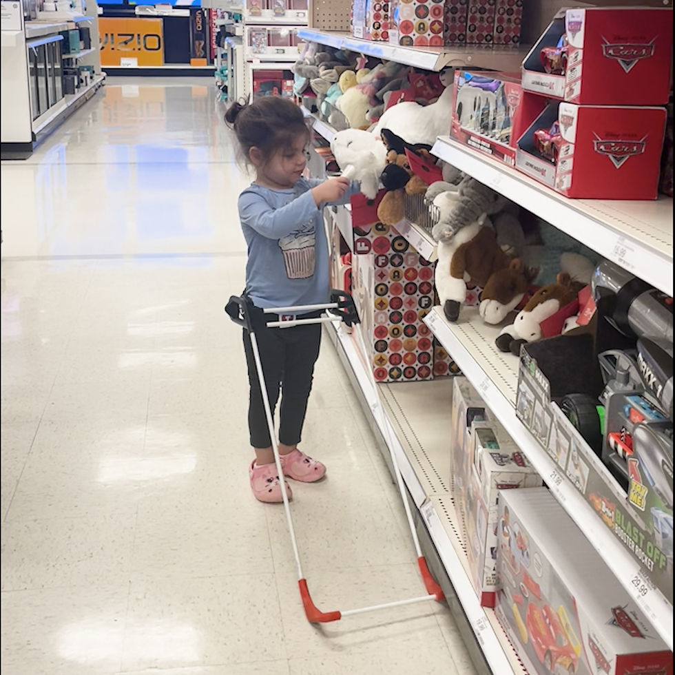 3-year-old blind child wearing her belt cane at the store is pulling a toy off the shelf by herself