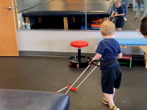 a boy wearing a belt cane walks past a mirror