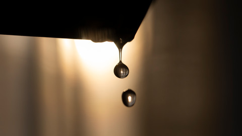 光の中で落ちる水滴、透明な丸い形