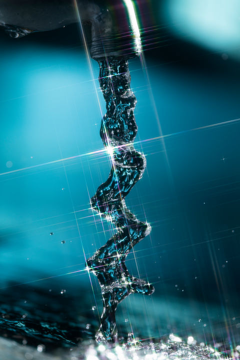 青い背景に輝く水が流れる