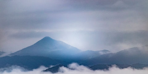 山の景色、曇り空の下の山々、霧の中、静かで雄大な風景。