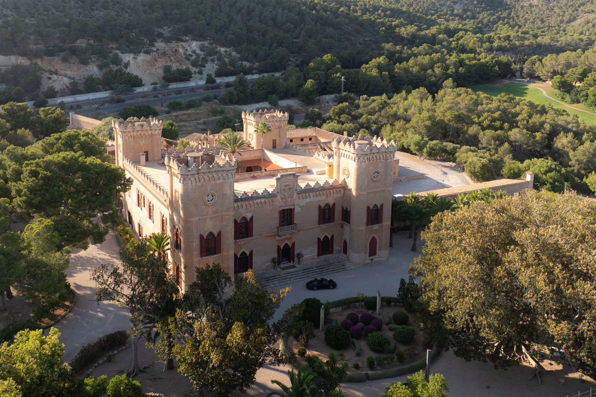 Aerial view of a castle-like wedding venue Castillo de Bendinat surrounded by trees and landscape in Mallorca, Spain