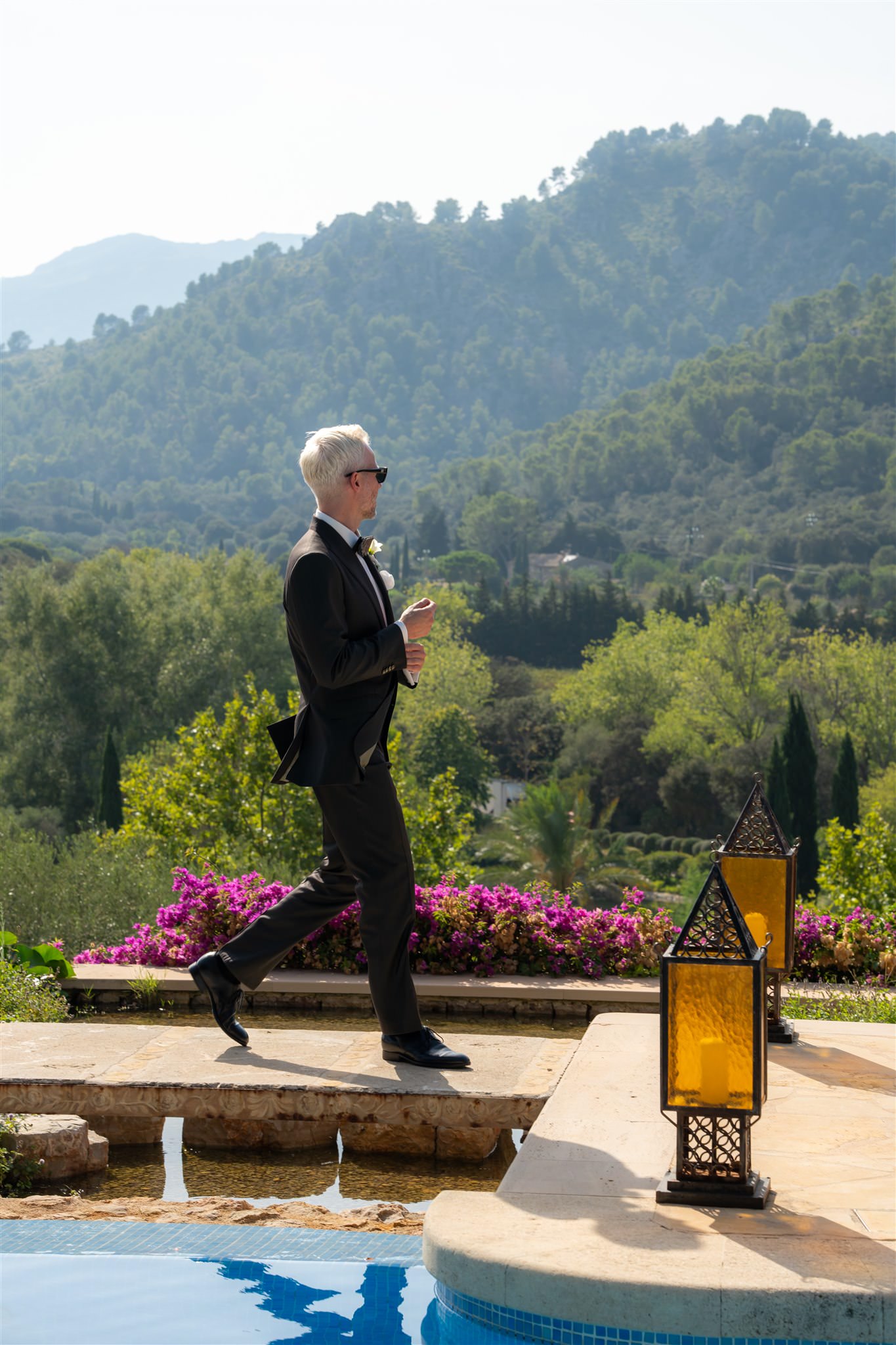 Groom standing outdoors in a suit overlooking landscape at luxury wedding venue 