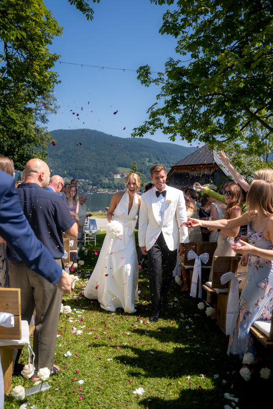 Bride and groom walking through guests at Tegernsee wedding.