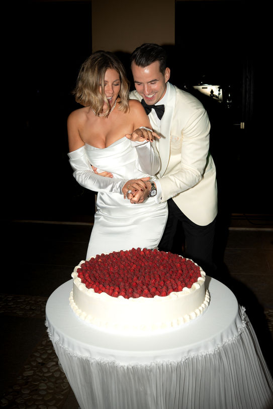 Bride and groom cutting wedding cake during Mallorca wedding reception.