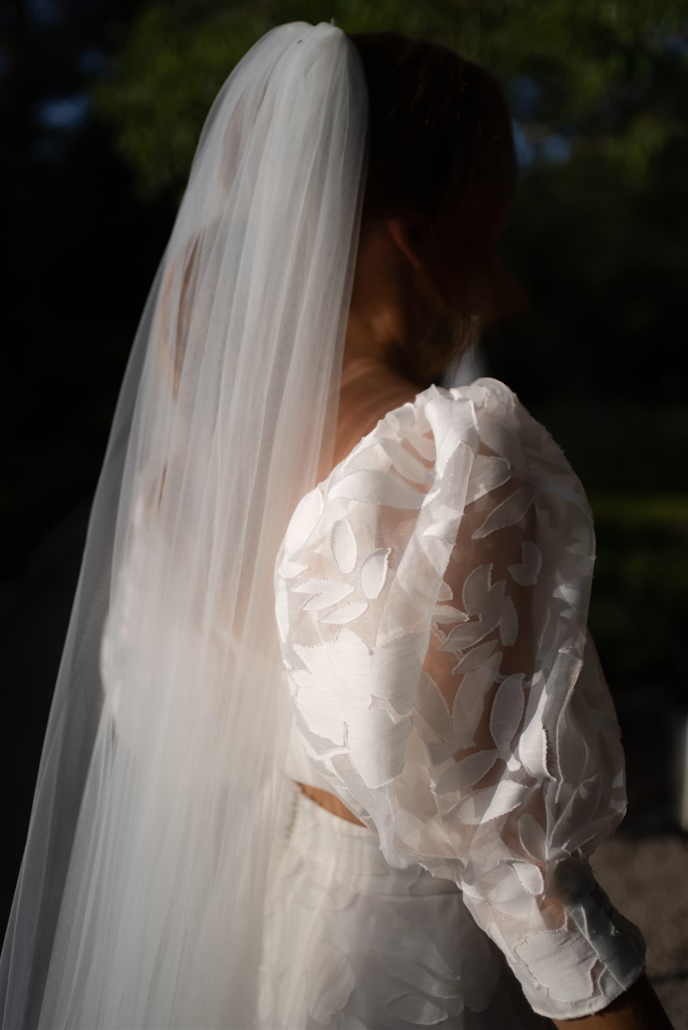 Bride with flowing veil captured in soft light creating an artistic and abstract wedding portrait