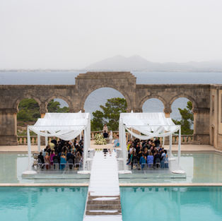 Iconic ceremony set up and view of La Fortaleza on the covered pool overlooking the sea