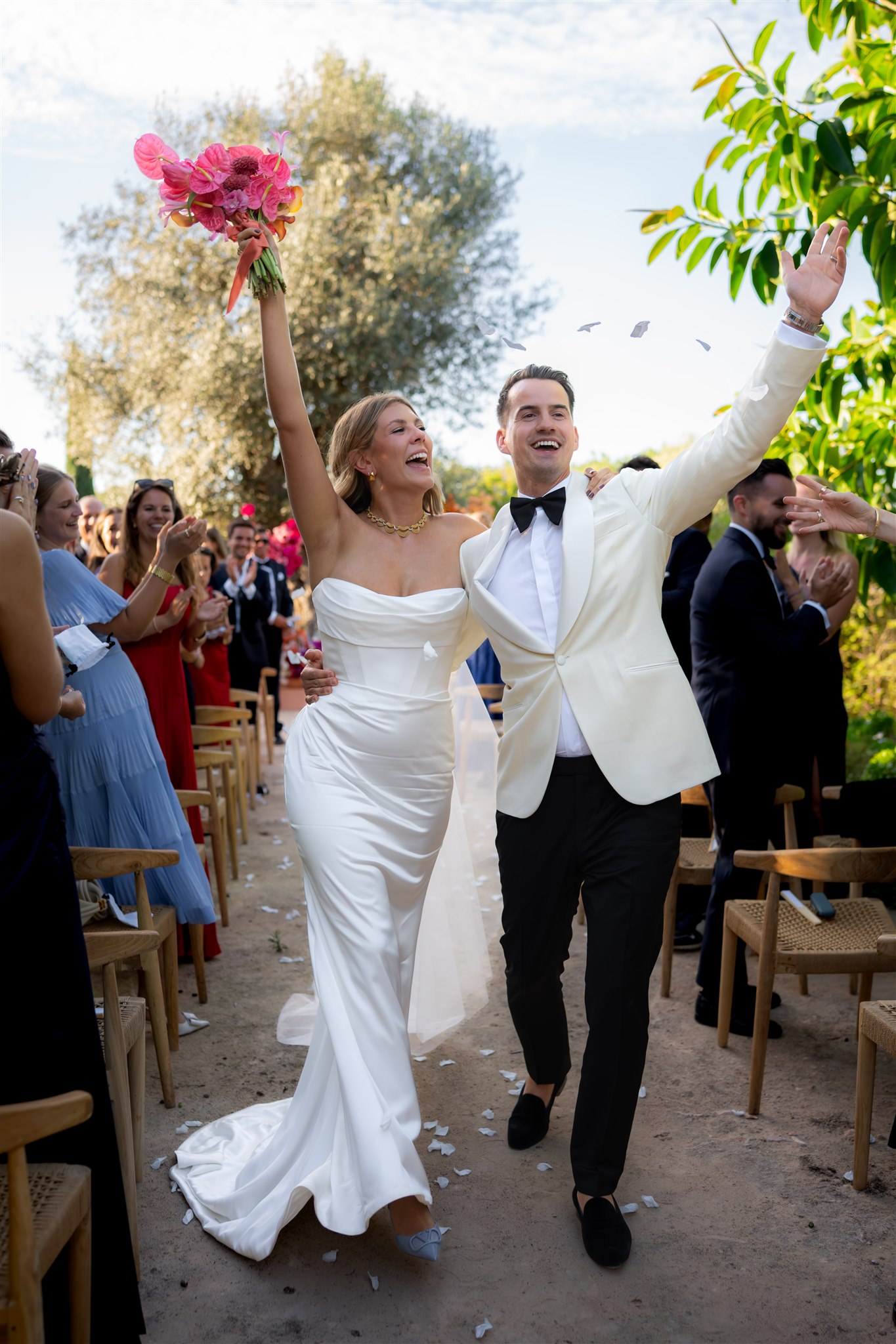 Bride and groom walking through guests cheering after ceremony