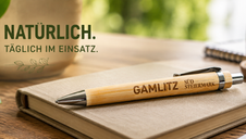 Lasergravierter Bambus Kugelschreiber mit Logo auf Notizbuch als nachhaltiger Werbeartikel für Unternehmen, Vereine, Weingüter und Tourismusbetriebe.