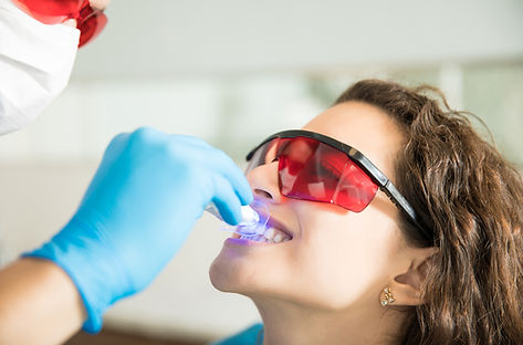 closeup-young-woman-having-her-teeth-whitened-with-ultraviolet-light-dental-clinic.jpg