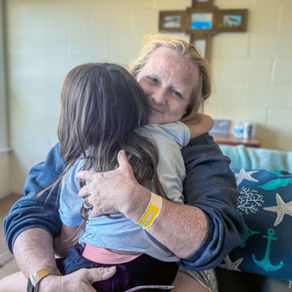 Houseparent hugs a child