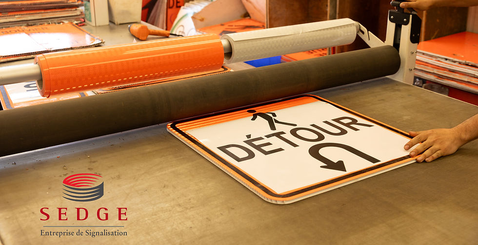 Custom traffic sign fabrication process at Sedge's production facility, where a reflective detour sign is being manufactured using professional laminating equipment. The image highlights Sedge's ability to create custom traffic control signage for construction projects, roadwork, and municipal traffic management throughout Montreal and Laval.