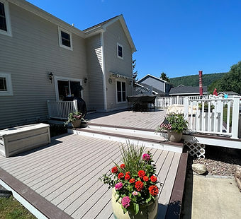 Gorgeous two-tier deck with two-tone picture framed composite decking and step lighting installed by Happy Homes CNY in Moravia, NY