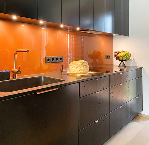 Custom built-in kitchen furniture. Black Gray lightweight concrete cabinet doors and cast concrete countertop sink.