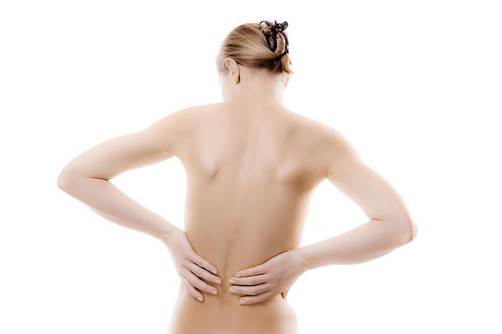 Person with hair up holds lower back, expressing discomfort. Neutral background. Light skin tones.